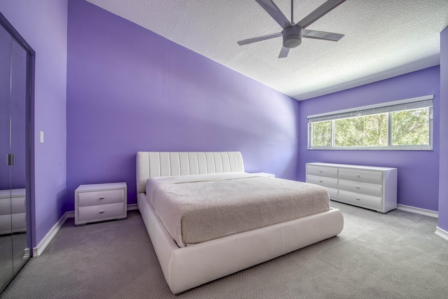 carpeted bedroom featuring a textured ceiling, baseboards, and a ceiling fan