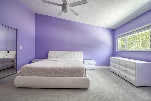 bedroom featuring carpet flooring, a textured ceiling, baseboards, and a ceiling fan