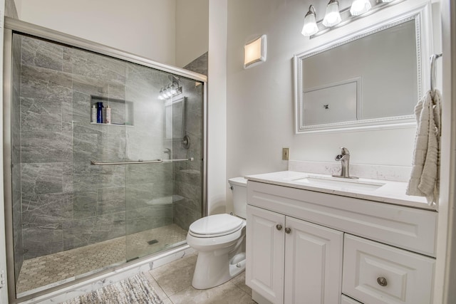 bathroom with a stall shower, vanity, toilet, and tile patterned floors