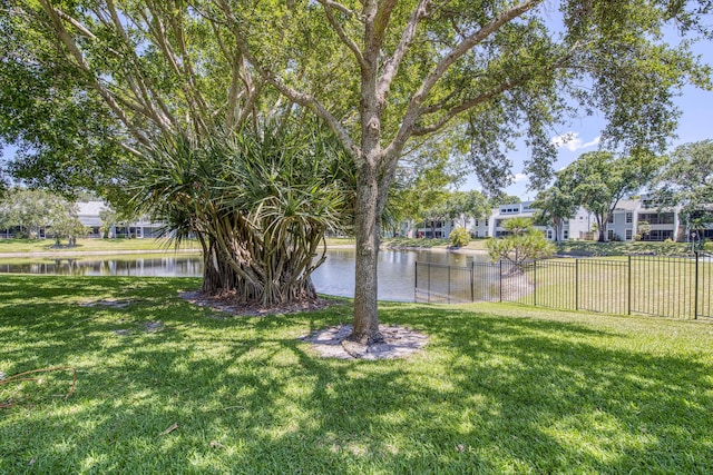 view of yard with a water view, a residential view, and fence
