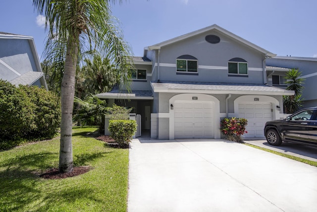 view of front facade with an attached garage, concrete driveway, stucco siding, and a front lawn