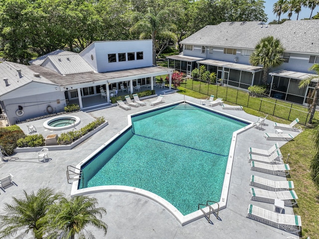 pool with a patio, a hot tub, and fence