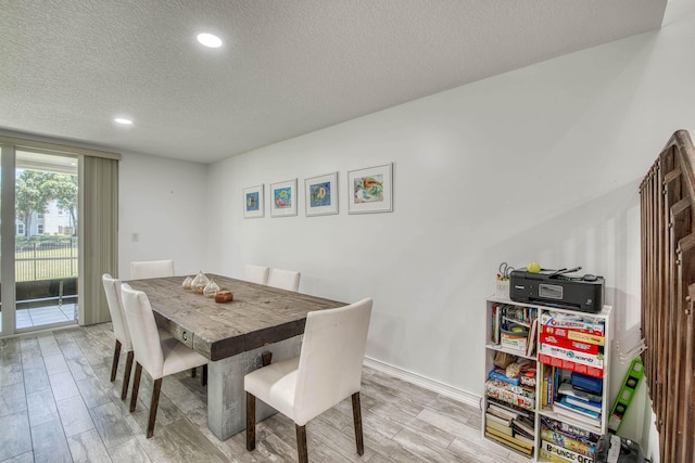 dining area featuring a textured ceiling, light wood-style flooring, baseboards, and recessed lighting
