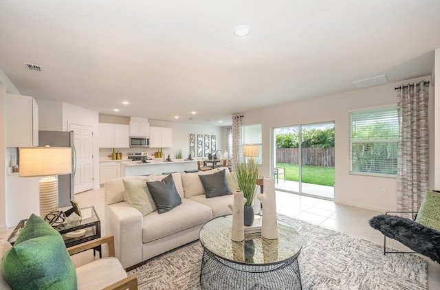 living room featuring light tile patterned floors, visible vents, baseboards, and recessed lighting