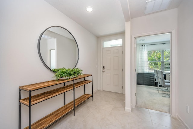 entrance foyer with recessed lighting, baseboards, light tile patterned floors, visible vents, and light colored carpet