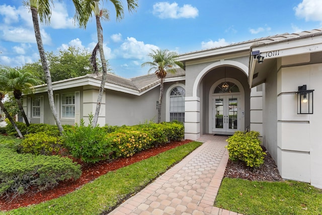 property entrance featuring stucco siding and french doors