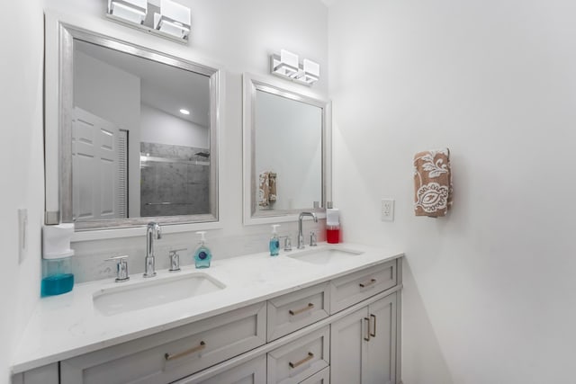 bathroom with a sink, double vanity, and a shower stall