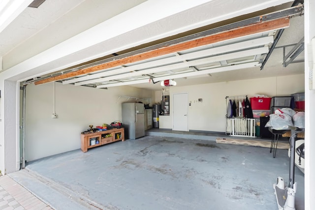 garage featuring freestanding refrigerator and a garage door opener