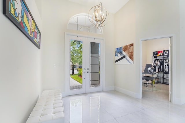foyer entrance featuring baseboards, tile patterned flooring, an inviting chandelier, and a high ceiling