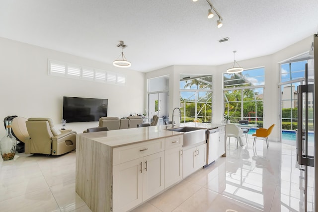 kitchen with a healthy amount of sunlight, light tile patterned flooring, and stainless steel dishwasher