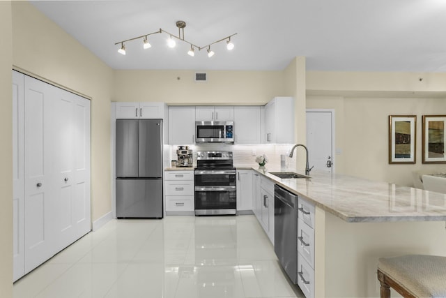 250 NE 3rd Ave Unit 1308, Delray Beach, FL 33444 - kitchen with a peninsula, a sink, visible vents, light stone countertops, and appliances with stainless steel finishes