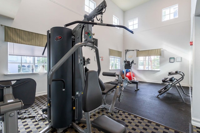 250 NE 3rd Ave Unit 1308, Delray Beach, FL 33444 - workout area with a towering ceiling, baseboards, and a healthy amount of sunlight