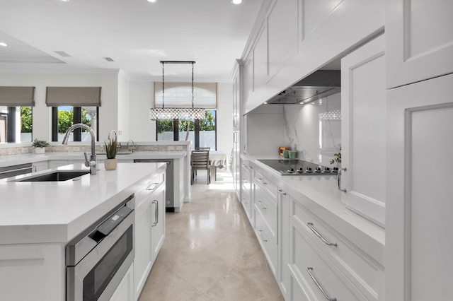 22175 Larkspur Trl, Boca Raton, FL 33433 - kitchen with a sink, stainless steel microwave, black electric stovetop, recessed lighting, and a kitchen island with sink