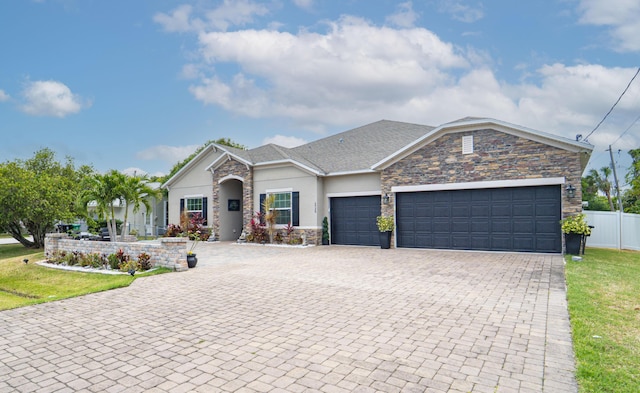 ranch-style house featuring stone siding, an attached garage, stucco siding, fence, and decorative driveway
