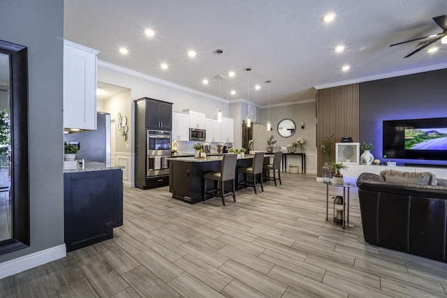 kitchen featuring a breakfast bar, ornamental molding, stainless steel appliances, and open floor plan