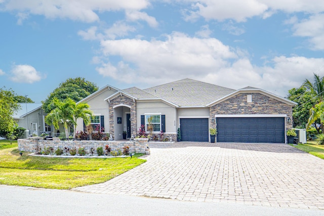 view of front of house featuring stone siding, a garage, stucco siding, a front lawn, and decorative driveway