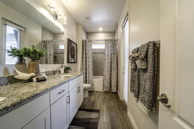 bathroom with a sink, toilet, visible vents, shower / bath combination with curtain, and double vanity