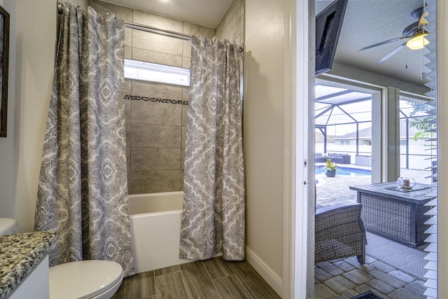 bathroom with toilet, baseboards, ceiling fan, shower / bathtub combination with curtain, and vanity
