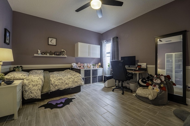 bedroom with lofted ceiling, a ceiling fan, and wood finish floors