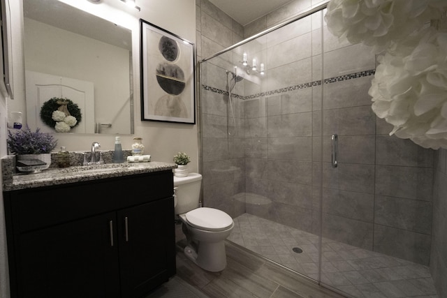 full bath featuring a stall shower, vanity, and toilet