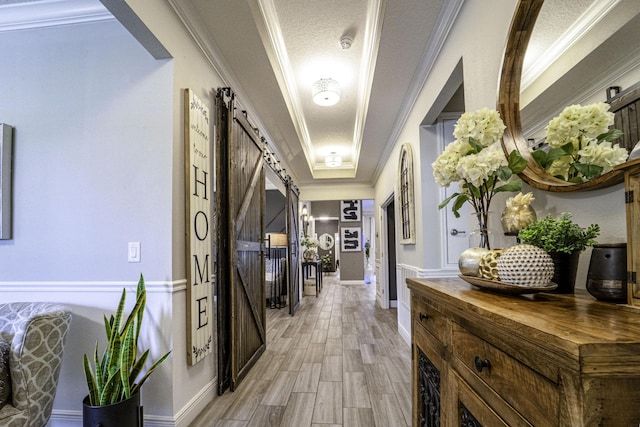 hallway featuring light wood-style floors, a barn door, and baseboards