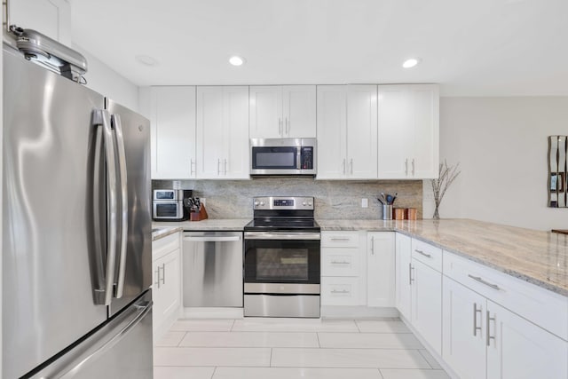 701 NE Harbour Ter Unit 103, Boca Raton, FL 33431 - kitchen with stainless steel appliances, white cabinetry, light tile patterned flooring, recessed lighting, and backsplash