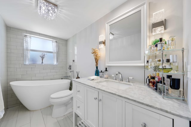 701 NE Harbour Ter Unit 103, Boca Raton, FL 33431 - bathroom featuring a freestanding bath, vanity, toilet, and tile patterned floors