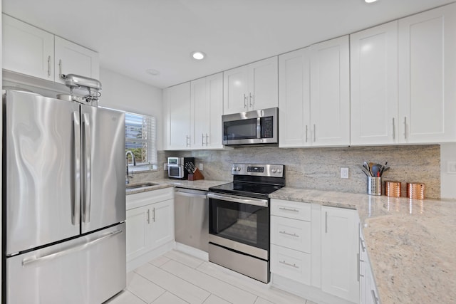 701 NE Harbour Ter Unit 103, Boca Raton, FL 33431 - kitchen with stainless steel appliances, a sink, light tile patterned floors, white cabinetry, and recessed lighting