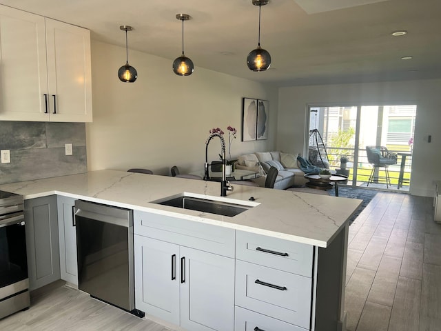3551 Inverrary Dr Unit 203, Lauderhill, FL 33319 - kitchen with appliances with stainless steel finishes, a sink, a peninsula, light wood-style flooring, and open floor plan