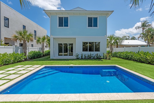 126 Auburn Dr, Lake Worth Beach, FL 33460 - rear view of house featuring a yard, stucco siding, a fenced in pool, and fence