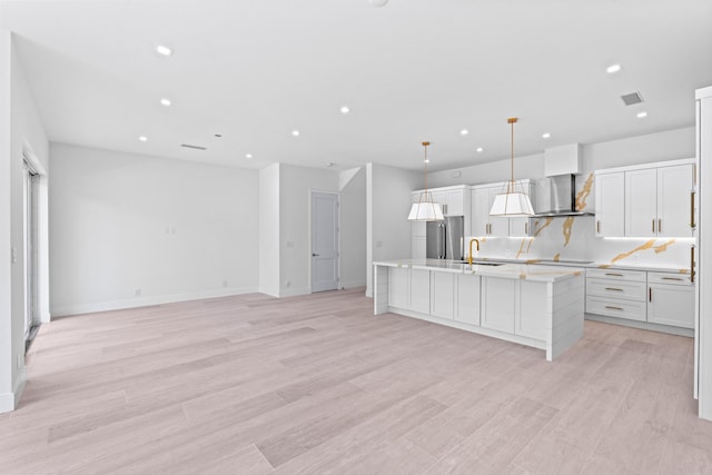 126 Auburn Dr, Lake Worth Beach, FL 33460 - kitchen with a sink, recessed lighting, a center island with sink, wall chimney exhaust hood, and light countertops