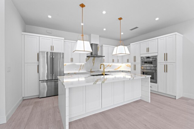 126 Auburn Dr, Lake Worth Beach, FL 33460 - kitchen featuring wall chimney range hood, light wood-style flooring, visible vents, and appliances with stainless steel finishes