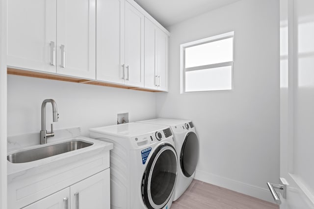126 Auburn Dr, Lake Worth Beach, FL 33460 - laundry room featuring a sink, cabinet space, washer and clothes dryer, light wood-type flooring, and baseboards