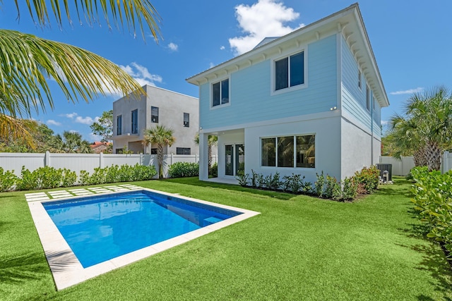 126 Auburn Dr, Lake Worth Beach, FL 33460 - back of house featuring fence, stucco siding, a fenced in pool, cooling unit, and a lawn