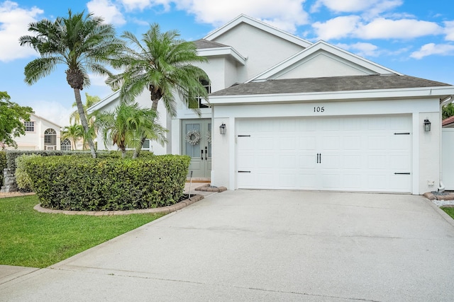 ranch-style house featuring concrete driveway, stucco siding, roof with shingles, and a garage