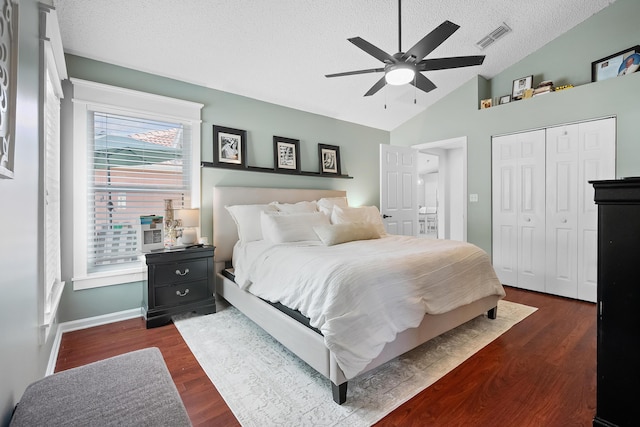 bedroom featuring a ceiling fan, a closet, a textured ceiling, dark wood finished floors, and visible vents