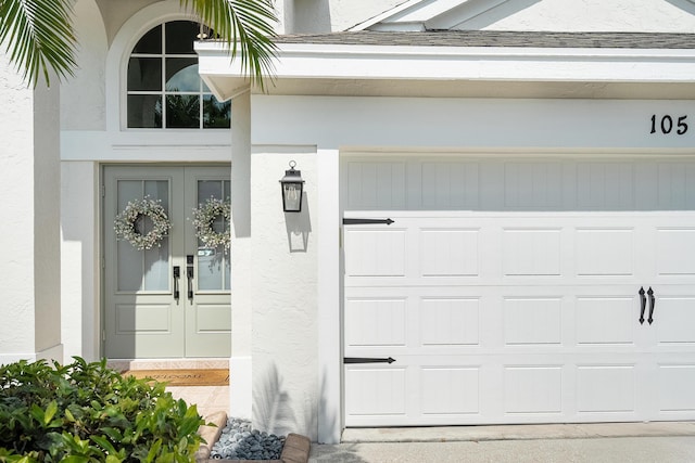 property entrance featuring stucco siding, french doors, and a garage