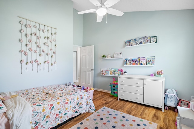 bedroom featuring baseboards, ceiling fan, high vaulted ceiling, and wood finished floors