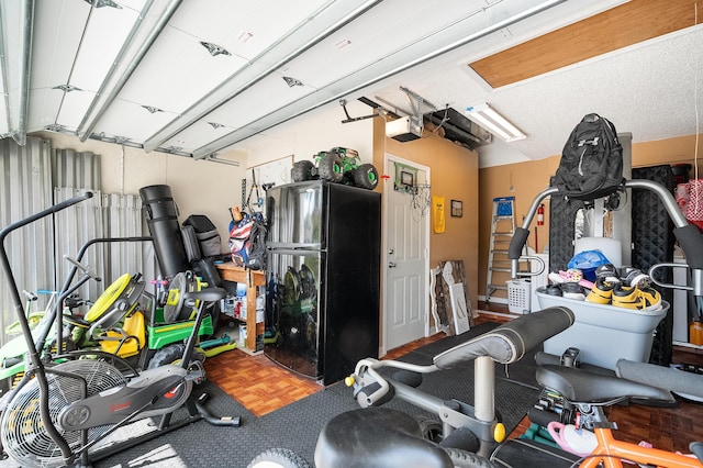 garage with freestanding refrigerator and a garage door opener