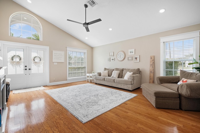 living room with a wealth of natural light, light wood-style floors, visible vents, and ceiling fan