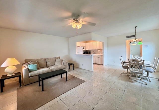 living room featuring light tile patterned floors, baseboards, visible vents, and ceiling fan with notable chandelier