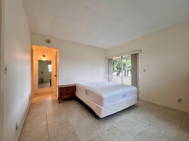 bedroom featuring light tile patterned floors, access to outside, and baseboards