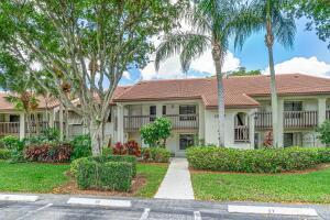 10137 Mangrove Dr Unit 203, Boynton Beach, FL 33437 - view of property featuring uncovered parking and a front lawn