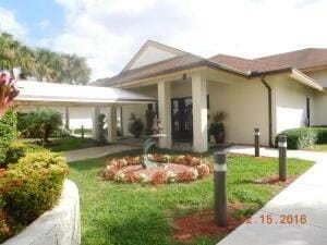 10137 Mangrove Dr Unit 203, Boynton Beach, FL 33437 - view of front of home featuring stucco siding and a front lawn