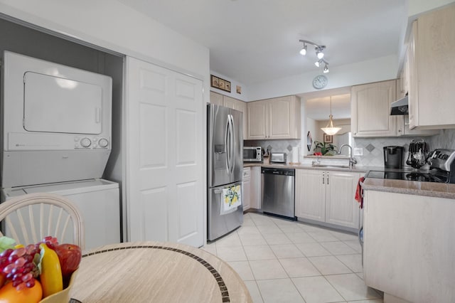14360 Strathmore Ln Unit 404, Delray Beach, FL 33446 - kitchen featuring stacked washer / drying machine, a sink, appliances with stainless steel finishes, tasteful backsplash, and light tile patterned flooring