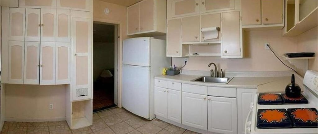 kitchen featuring white appliances, light countertops, white cabinets, and a sink