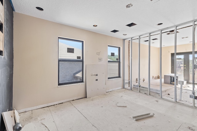 2924 Deer Run Trl, Loxahatchee, FL 33470 - unfurnished room featuring plenty of natural light, a textured ceiling, and baseboards