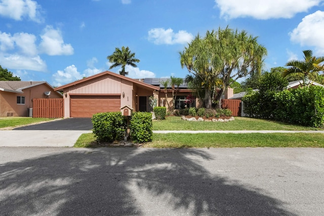 650 NW 48th Ave, Coconut Creek, FL 33063 - single story home featuring fence, an attached garage, driveway, a front yard, and roof mounted solar panels