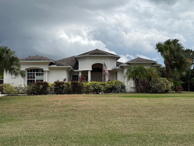 mediterranean / spanish home with stucco siding and a front yard