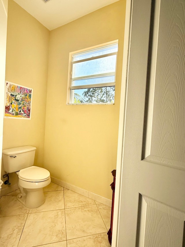 bathroom featuring toilet, tile patterned flooring, and baseboards